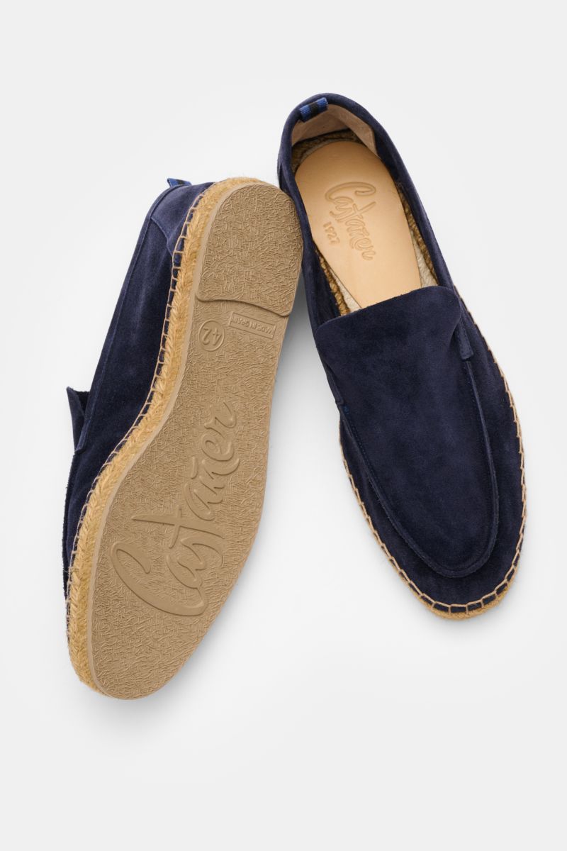 Castañer Espadrilles 'Nino T' navy shown from a top and side angle, made of soft navy velour leather with jute trim, decorative front seam, pull loop, and flexible rubber sole. Sommerliche Leichtigkeit in Schuhform: Die Espadrilles 'Nino T' von CASTAÑER a