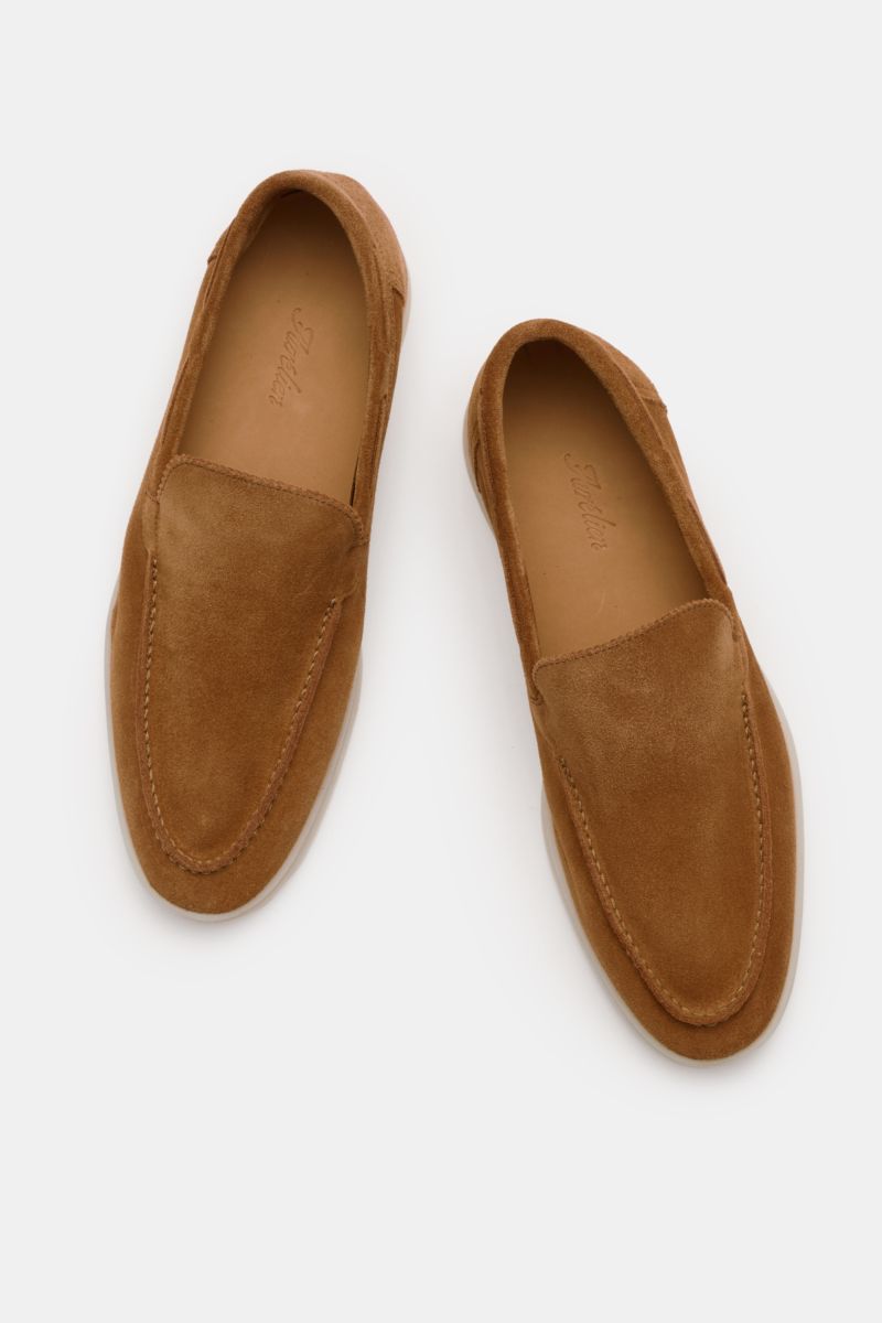 Top-down view of a pair of Aurélien Loafer 'Yacht 2.0' hellbraun shoes in soft light brown suede with hand-stitched details, a slim silhouette, leather lining, and flexible rubber soles, showcasing ultimate comfort and craftsmanship with subtle zigzag edg