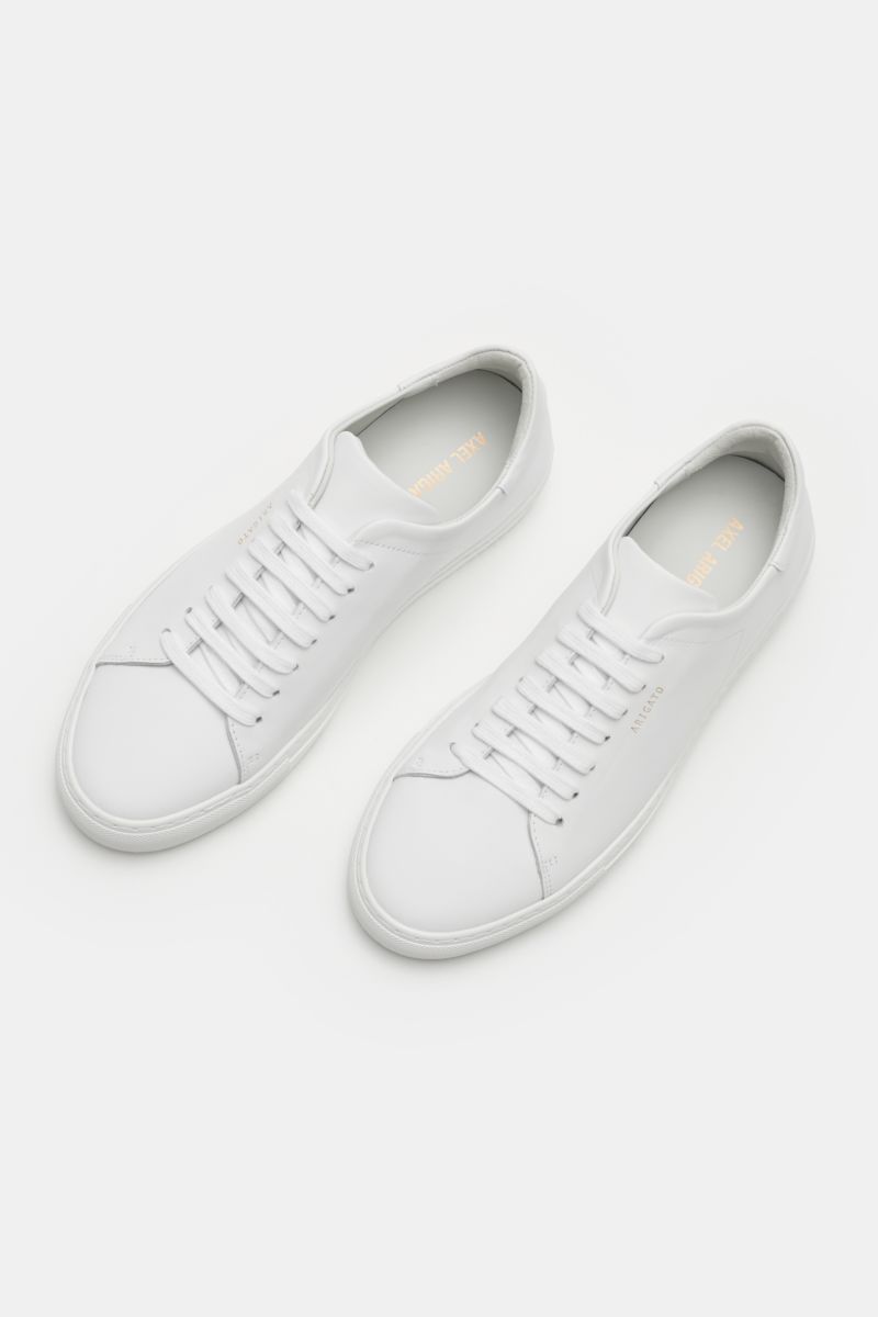 Axel Arigato Sneaker 'Clean 90' weiß aus hochwertigem Glattleder, runder Vorderkappe, Sieben-Loch-Schnürung, gepolstertem Schaftrand, Innenfutter aus Leder, goldfarbener Prägung, flexibler Gummisohle, fotografiert von oben.