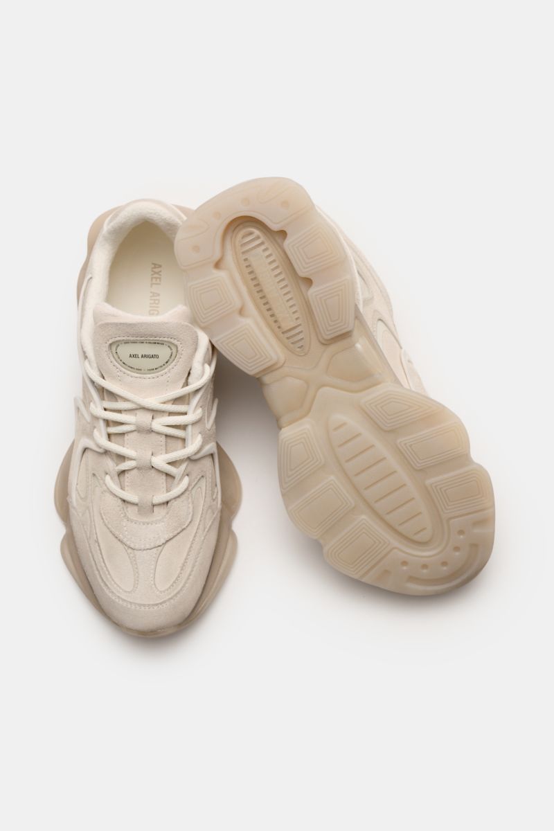 Axel Arigato Sneaker 'Eris' offwhite shown from a top and bottom view, featuring noble velour leather, overlays of velour and smooth leather, narrow silhouette, four-eyelet lacing, logo patch on the tongue, textile lining, and rubber outsole.