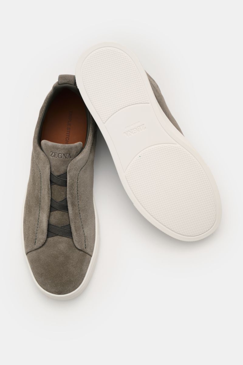 Zwei Zegna Slip-on-Sneaker 'Triple Stitch' grau aus Veloursleder, von oben fotografiert, mit elastischen Bändern und flexibler Gummisohle.