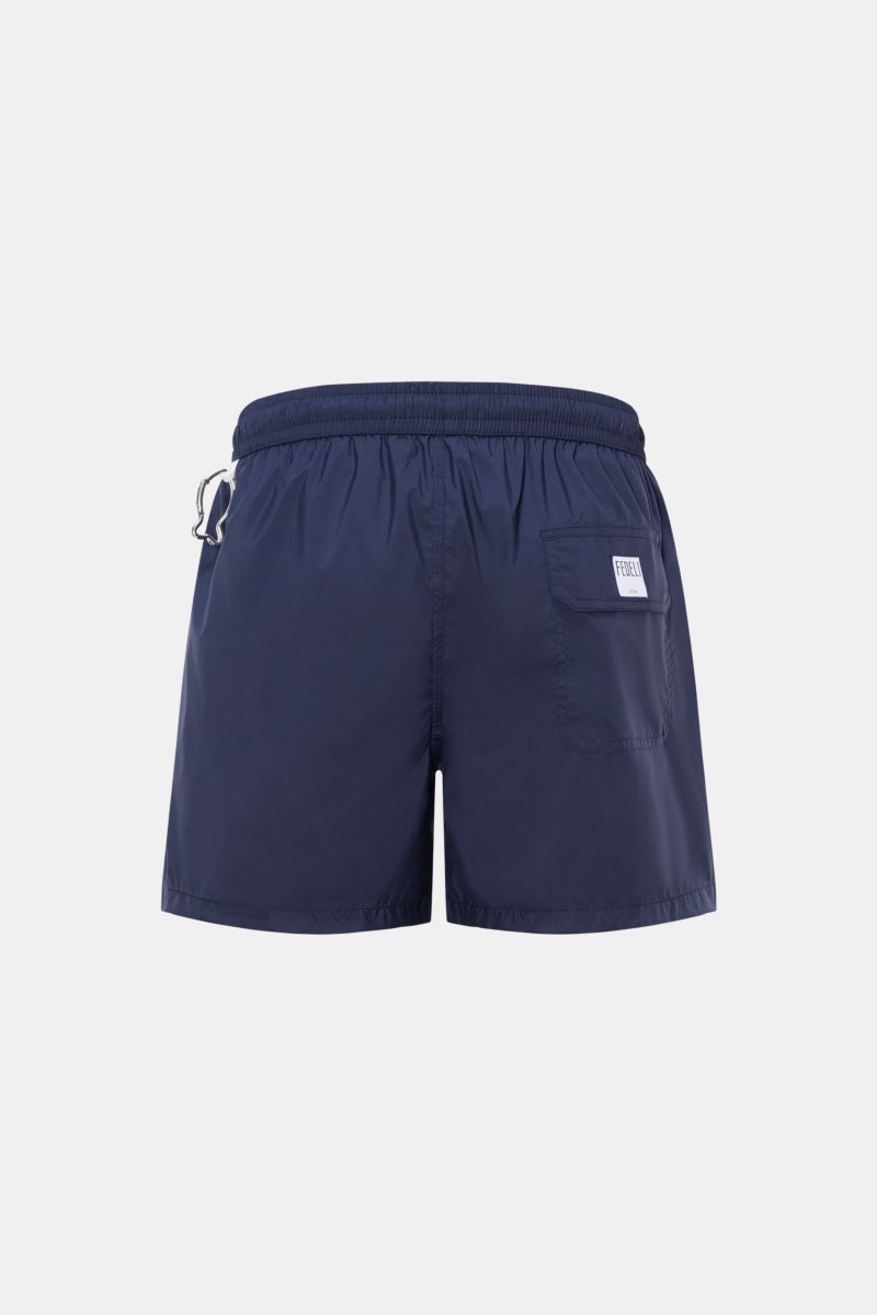 Fedeli Swim shorts 'Madeira Airstop' navy shown from the back, featuring elastic waistband, side pockets, back pocket with label, and whale-shaped carabiner. The swim shorts 'Madeira Airstop' by FEDELI are a timeless model for your suitcase. With their