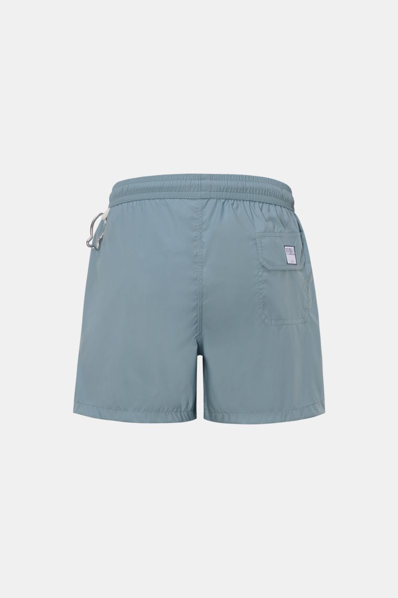 Rear view of Fedeli Swim shorts 'Madeira Airstop' smoky blue with elastic waistband, back pocket, whale-shaped carabiner, and short hem vents.

Description: The swim shorts 'Madeira Airstop' by FEDELI are a timeless model for your suitcase. With their 