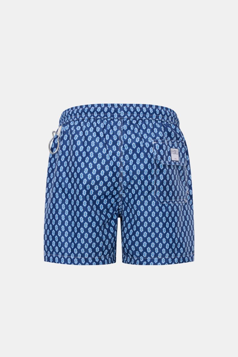 Rear view of Fedeli Swim shorts 'Madeira Airstop' dark blue/blue/white patterned with elastic waistband, back pocket, and whale-shaped carabiner.

An essential for your summer vacation: These FEDELI swim shorts have an expressive pattern that adds styl