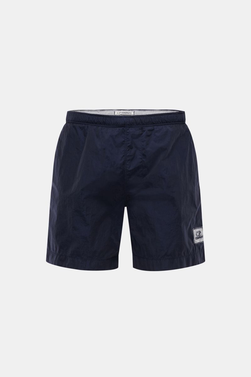C.P. Company Badeshorts navy in Frontansicht, glänzend, elastischer Bund, schnell trocknende Microfaser, Logo-Patch, Regular Fit, Mesh-Innenfutter, französische Taschen.
