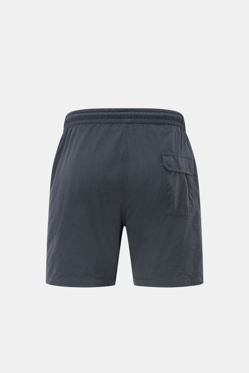 Rear view of 04651/ A trip in a bag Swim shorts 'Mono Seersucker' navy, made of seersucker microfiber with elastic waistband, drawstring, side and back pockets, side vents, and mesh lining. Perfect for your next summer holiday: With their design in seersu