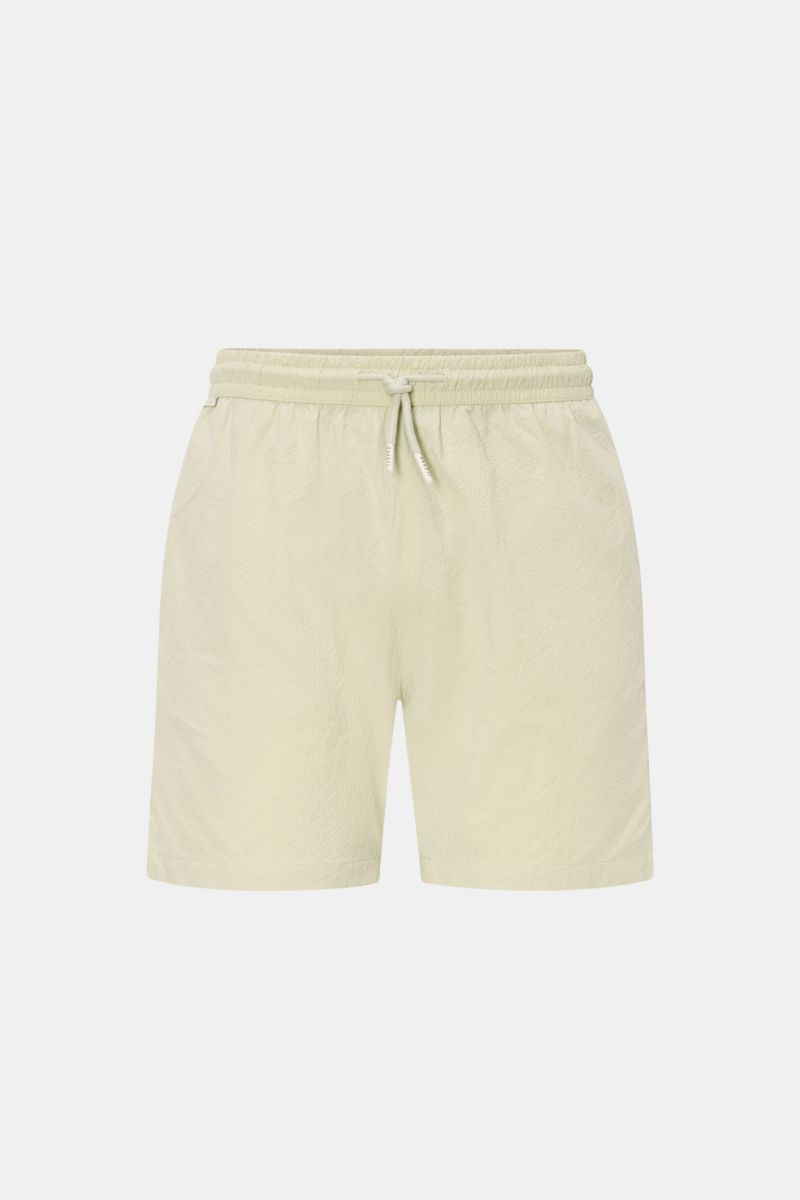 Front view of 04651/ A trip in a bag Swim shorts 'Mono Seersucker' sage in light green with elastic waistband and drawstring.

Description: Perfect for your next summer holiday: With their design in seersucker look, these swim shorts by 04651/ A TRIP I