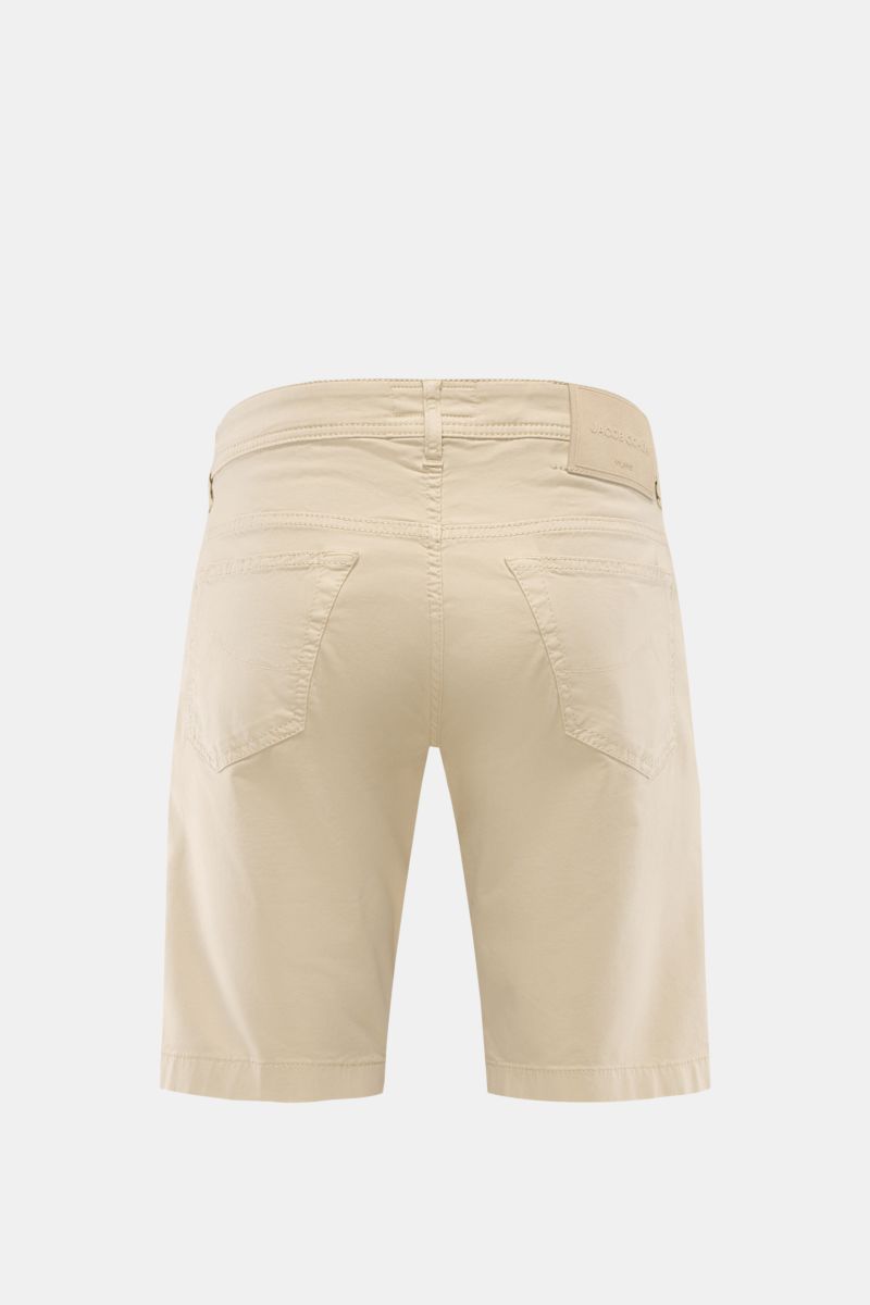 Rear view of Jacob Cohen Bermudas 'Lou' beige, showing fine twill fabric, patch back pockets, and leather patch on waistband.

Description: Summer as it should be: The 'Lou' bermudas by JACOB COHEN combine the distinctive style of the Italian denim lab