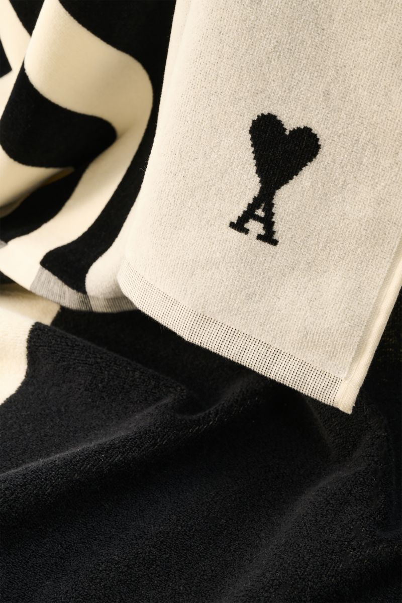 Close-up view of the Ami Paris Strandtuch schwarz/weiß gestreift showing soft cotton terry fabric with black and white stripes and the brand’s heart logo.

Luxuriöser Begleiter für sonnige Tage: Mit seinem ikonischen Streifendesign und der soften Baumw