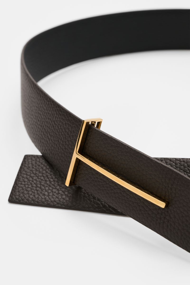 Close-up perspective of the Tom Ford Gürtel schwarz/dunkelbraun, a reversible belt in pebbled calf leather with a gold-tone brass buckle, width approx. 3.5 cm.

Description based on provided content:  
Eleganter Eyecatcher: Mit seinem zeitlosen Look wi