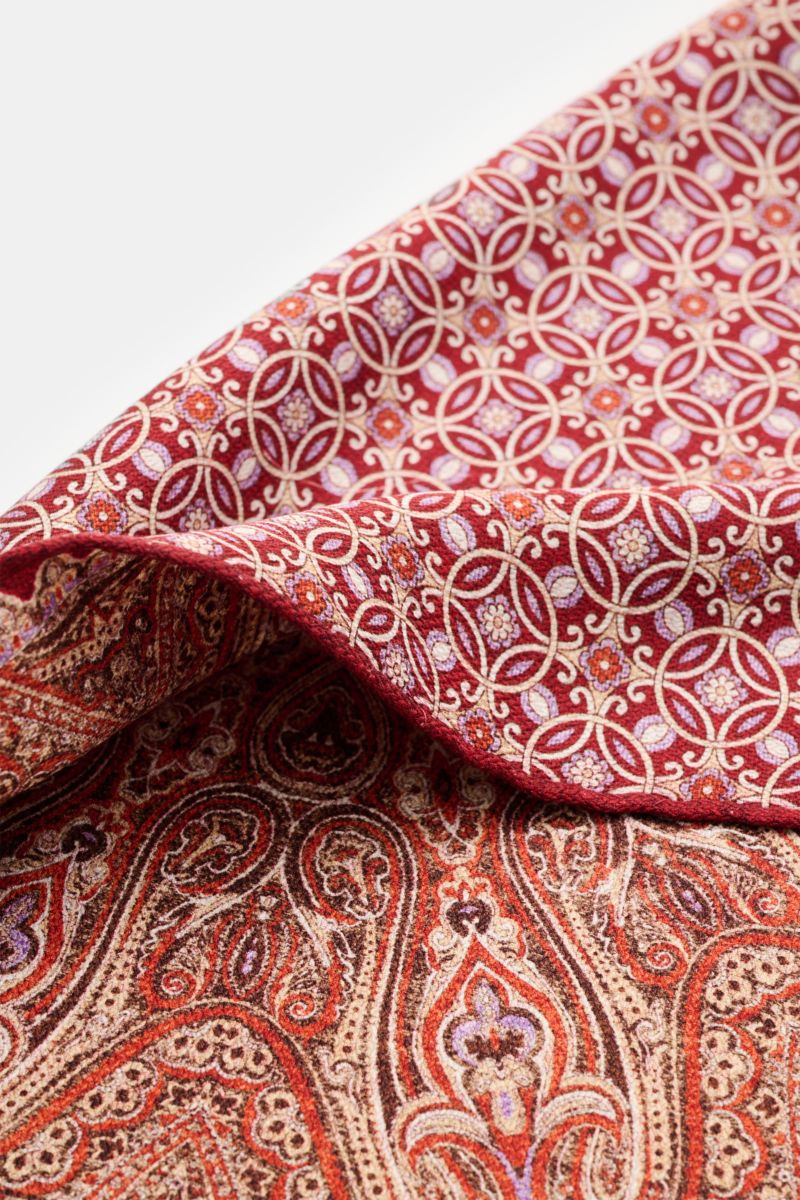 Rosi Collection Einstecktuch 'Easy' rot/orange/beige gemustert, aus reiner Seide mit modernem Paisley-Muster, Vorder- und Rückseite, rollierte Kanten, Detailaufnahme schräg von oben, Made in Italy, ca. 31x31 cm.