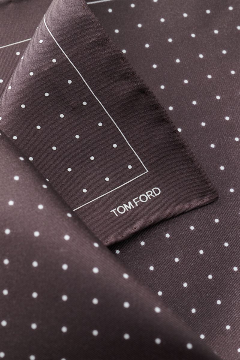 Tom Ford Seiden-Einstecktuch dunkelbraun/weiß gepunktet, aus reiner Seide mit rollierten Kanten, kleiner TOM FORD-Print, Nahaufnahme von oben.