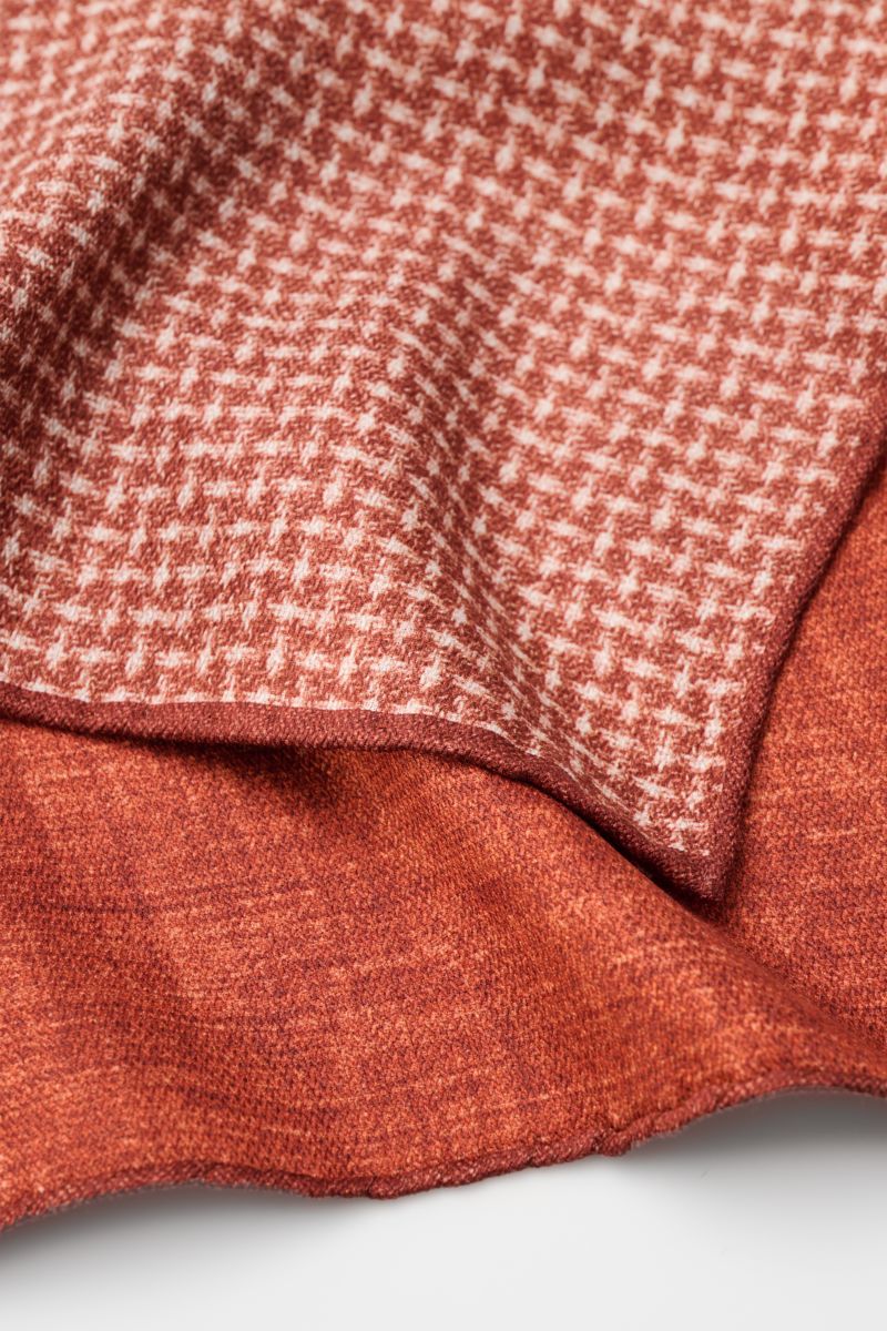 Brunello Cucinelli Seiden-Einstecktuch rostbraun/off-white gemustert, reine Seide, geschmeidiger Griff, Webmuster, handrollierte Kanten, Made in Italy, ca. 35x35 cm, Nahaufnahme von oben.