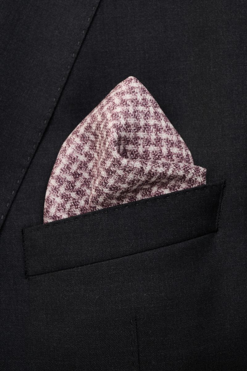 Close-up front view of a navy/grau/dunkelbraun patterned Brunello Cucinelli Seiden-Einstecktuch in a dark jacket pocket, featuring reine Seide, geschmeidiger Griff, Glencheck, Punkte auf der Rückseite, handrollierte Kanten, Made in Italy, Maße: ca. 35 cm 