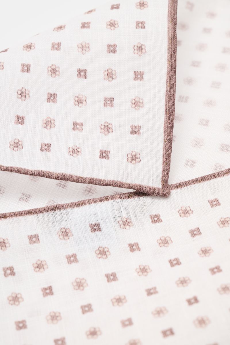 Close-up angled top view of the Rosi Collection Linen pocket square 'Fox' white/brown patterned, pure linen with soft feel, floral print, rolled edges, made in Italy, dimensions 31.5 cm x 31.5 cm.