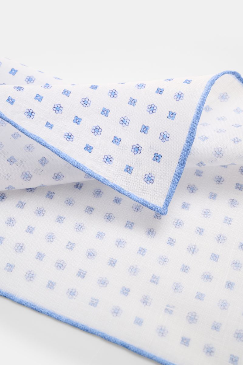 Rosi Collection Linen pocket square 'Fox' white/blue patterned shown from a close-up angled top view, pure linen, soft feel, floral print, rolled edges, made in Italy, dimensions 31.5 cm x 31.5 cm.
