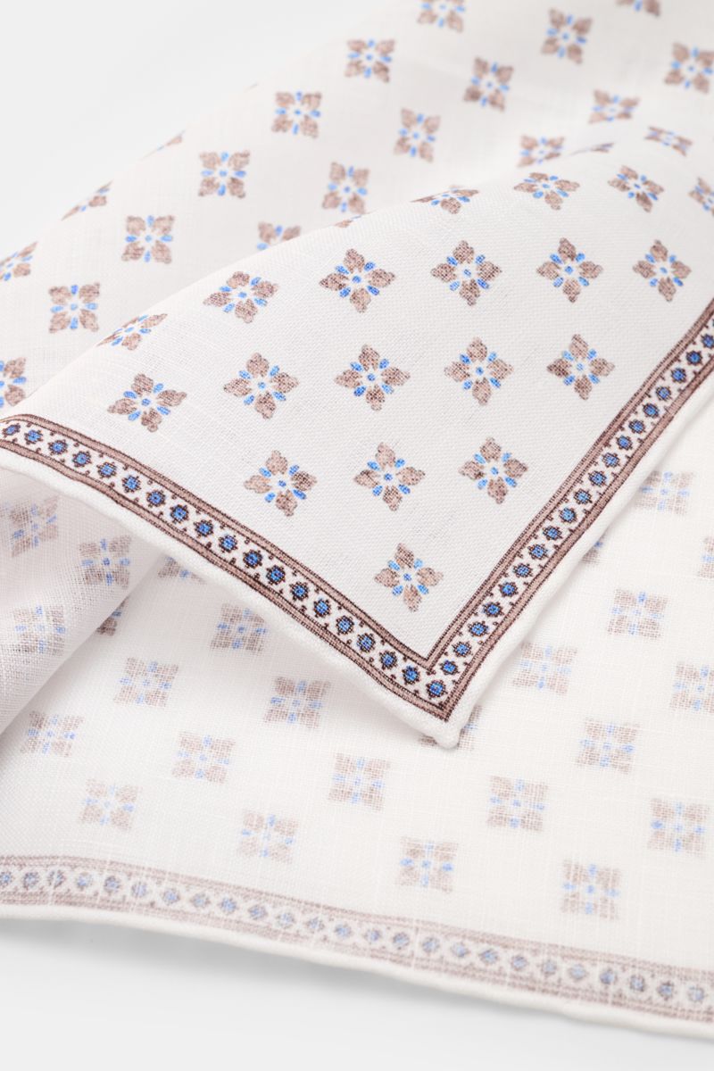 Rosi Collection Linen pocket square 'Fox' white/brown/blue patterned shown from a close-up top angle, pure linen, soft feel, floral print with edging, rolled edges, made in Italy, dimensions 31 cm x 31 cm.