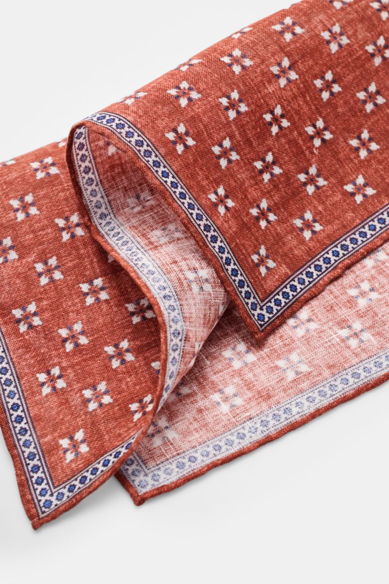Rosi Collection Linen-pocket square 'Fox' blue/dark brown/off-white patterned, pure linen, soft feel, floral print with edging, rolled edges, made in Italy, 31x31 cm, close-up angled view.