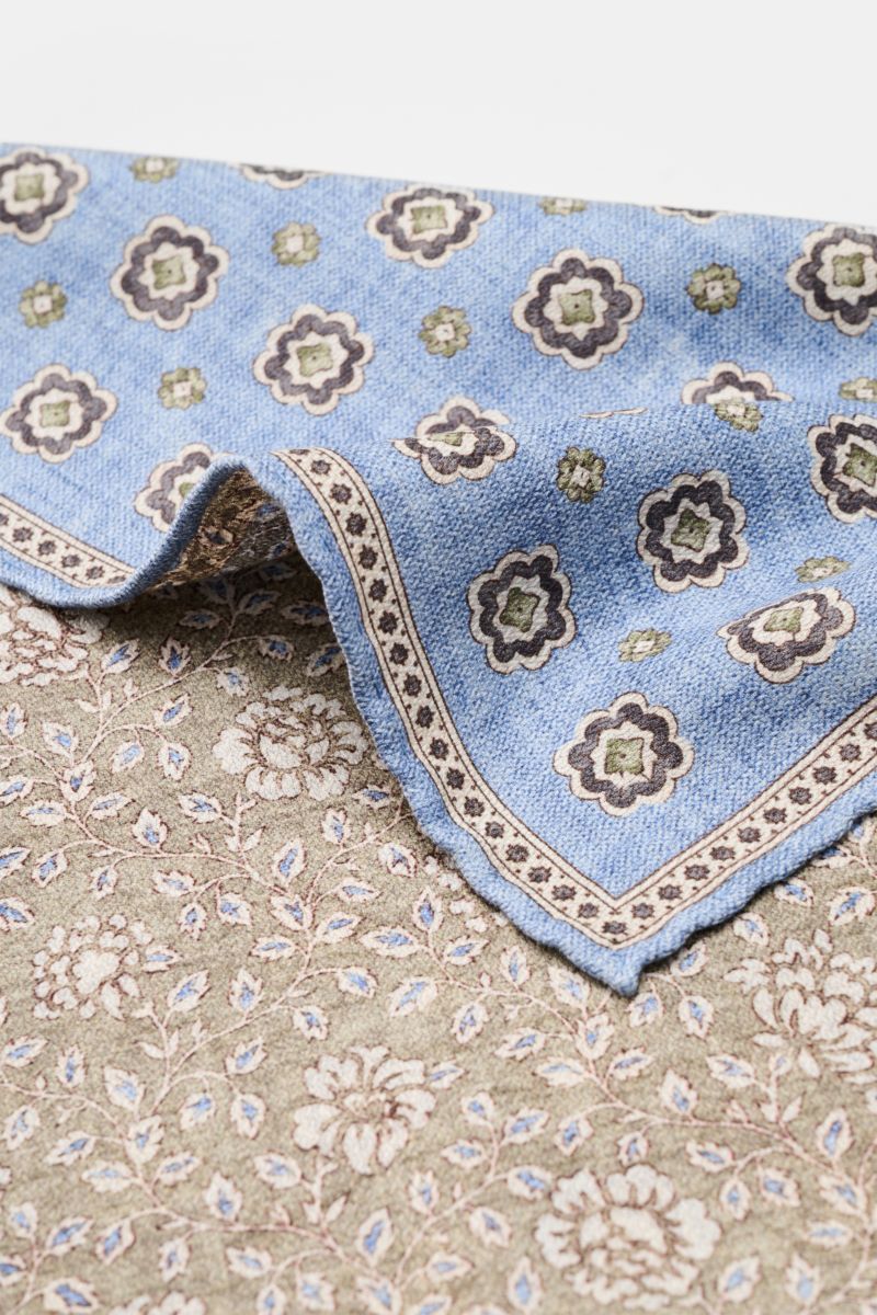 Rosi Collection Seiden-Einstecktuch 'Easy' hellblau/oliv/creme gemustert shown from a close-up top angle, featuring reine Seide, softer, geschmeidiger Griff, eleganter Medaillon-Print mit Borte, florale Rückseite, rollierte Kanten, Made in Italy, Maße ca.