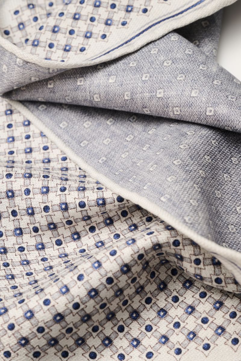 Brunello Cucinelli Seiden-Einstecktuch sand/navy/grau gemustert, weich fallend, doppelseitig mit grafischem Print und rollierten Kanten, Nahaufnahme.