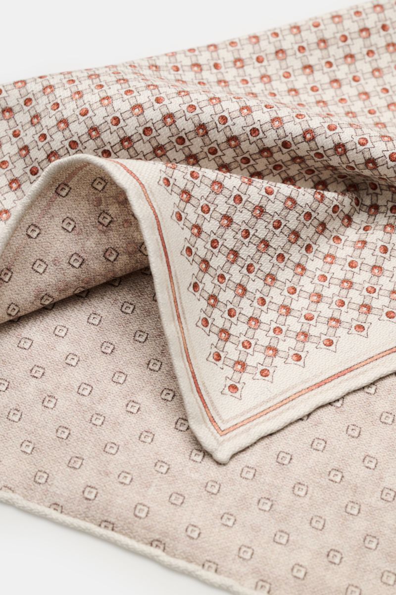 Close-up angled view of the Brunello Cucinelli Silk pocket square 'Fox' sand/rust brown/beige patterned, showing graphic print with rolled edges.

Description:
Elegant and eye-catching: This pocket square in pure silk by BRUNELLO CUCINELLI creates an e