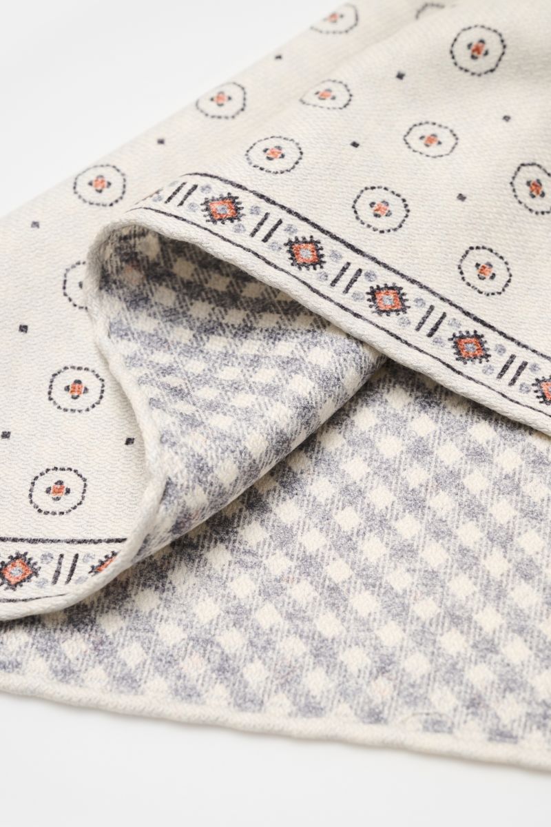 Brunello Cucinelli Seiden-Einstecktuch offwhite/apricot/navy gemustert shown folded from a close-up angle, featuring graphic print, silk, and contrasting patterns.

Zeitloser Akzent für besondere Momente: Das Einstecktuch aus reiner Seide von BRUNELLO 