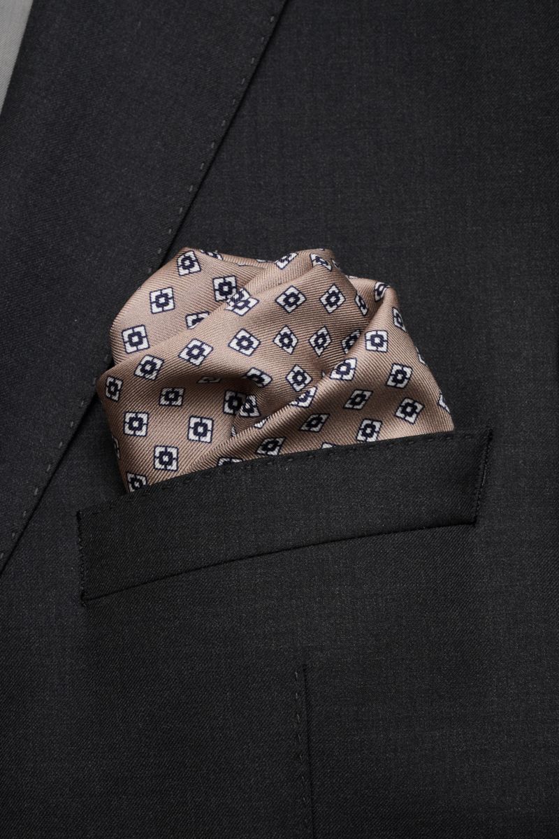 Close-up front view of a Brunello Cucinelli Seiden-Einstecktuch navy/rauchblau pocket square in a black suit pocket with a subtle geometric pattern.

Quiet Luxury kann BRUNELLO CUCINELLI besonders gut und bringt auch in dieser Saison passende Einsteckt