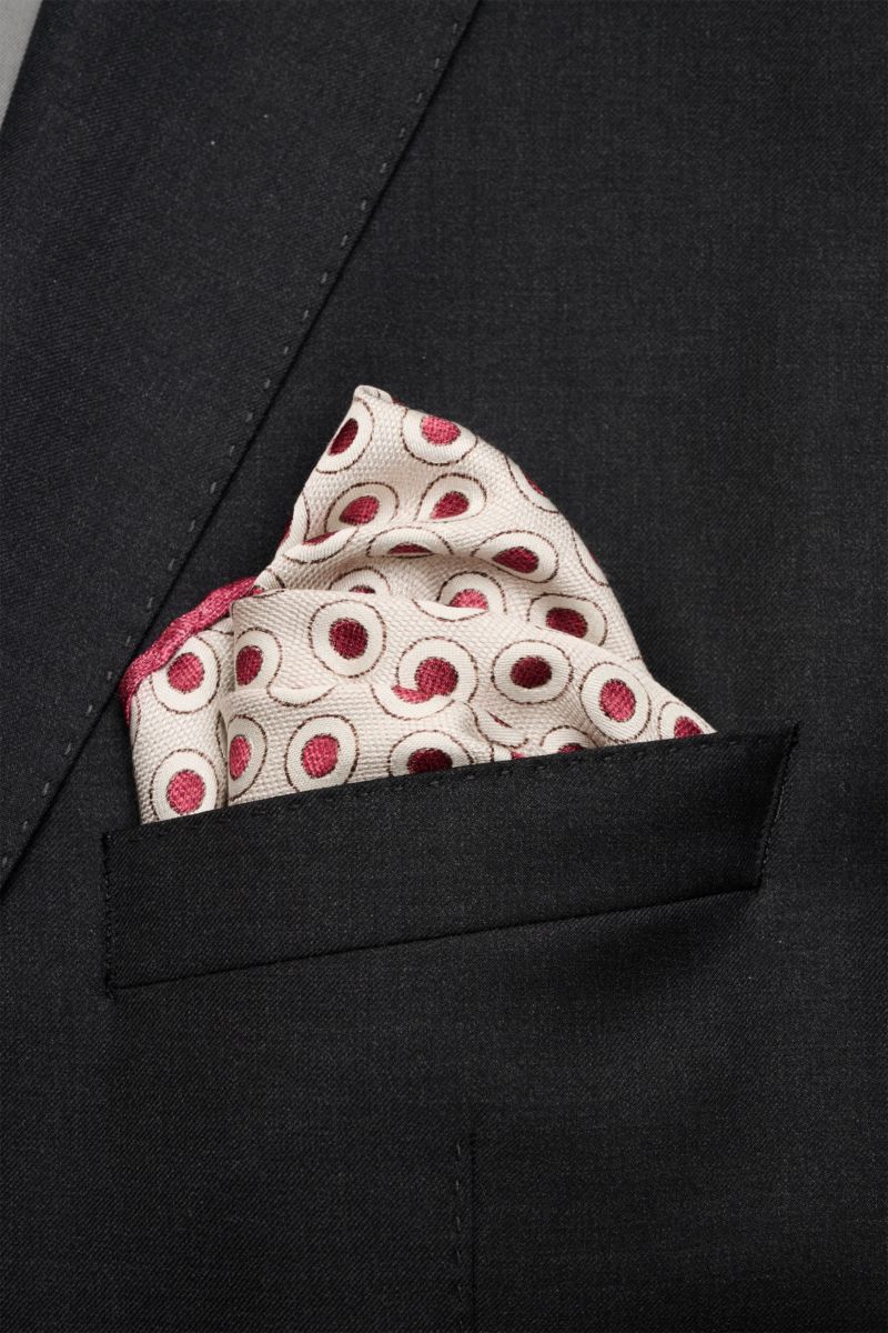 Close-up front view of Brunello Cucinelli Seiden-Einstecktuch dunkelrot/beige gepunktet silk pocket square in a black suit pocket, featuring a subtle polka dot pattern.

Description: Quiet Luxury heißt der große Trend: Das kann BRUNELLO CUCINELLI beson