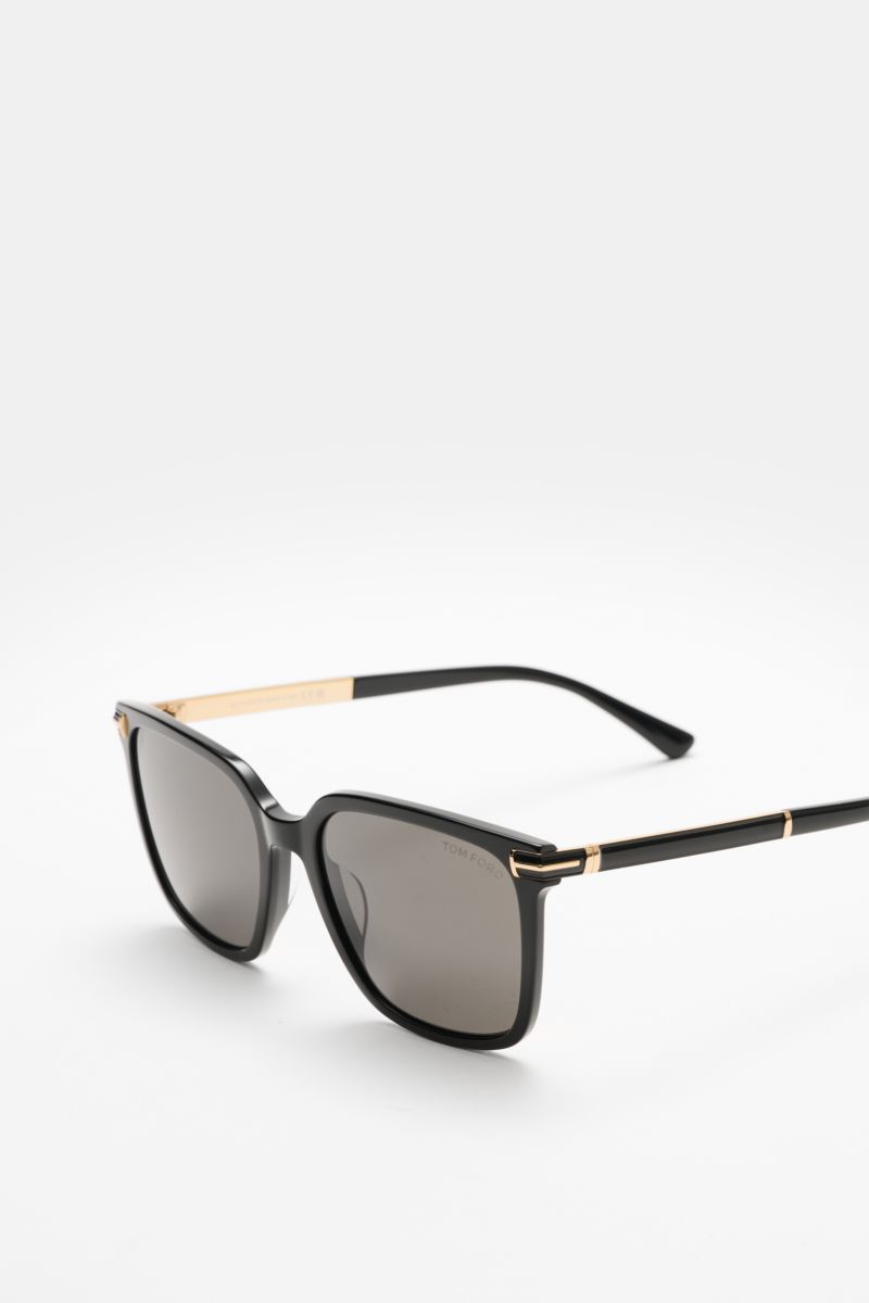 Front-side angled view of Tom Ford Sunglasses 'Jochem' black with slightly square acetate frame, evenly tinted plastic lenses, and gold accents.

Stylish all-rounder: With their timeless design, these sunglasses by TOM FORD are an ideal summer essentia