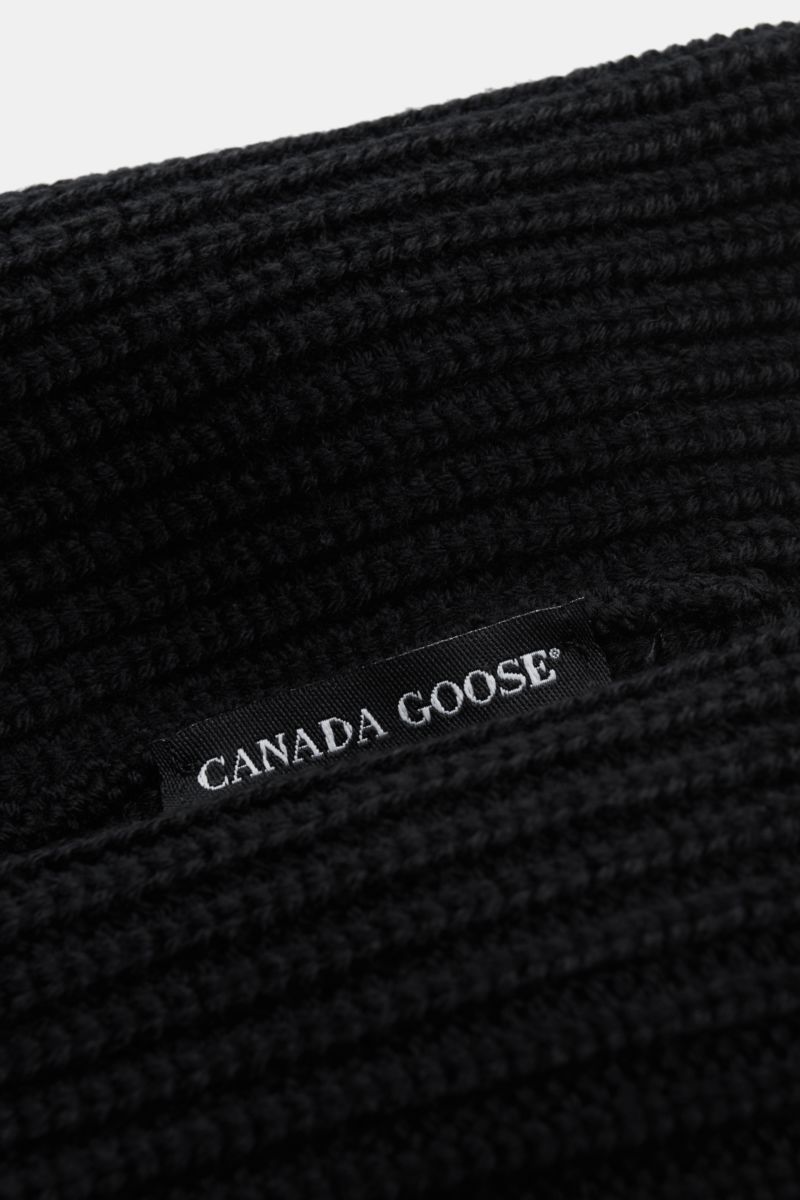 Close-up front view of the Canada Goose Wollmütze schwarz showing its coarse ribbed knit design and folded cuff with black woven label.

Must-Have für die kühle Jahreshälfte: Mit der Mütze aus reinem Woll-Rippstrick vom Outdoor-Experten CANADA GOOSE kö