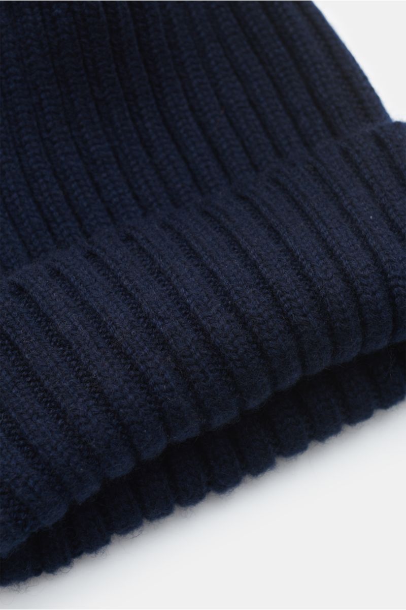 Fedeli Cashmere Mütze navy aus reiner, weicher Cashmere in breitem Rippstrick mit variablem Umschlag, Nahaufnahme von schräger Seitenperspektive.