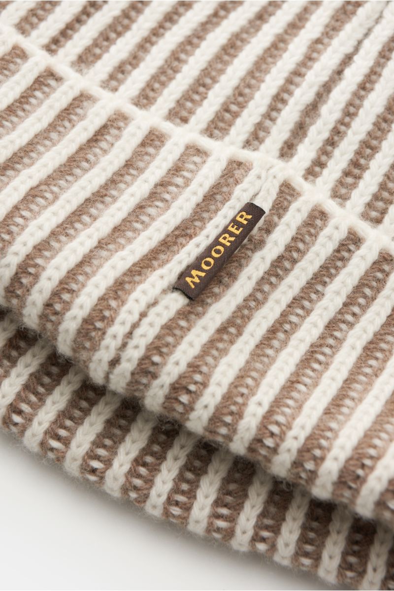 Close-up angled view of the Moorer Beanie 'Davis-WSV' white/taupe striped showing a blend of wool and cashmere, very soft feel, two-tone brioche pattern, chunky knit, and a small woven label in the seam.