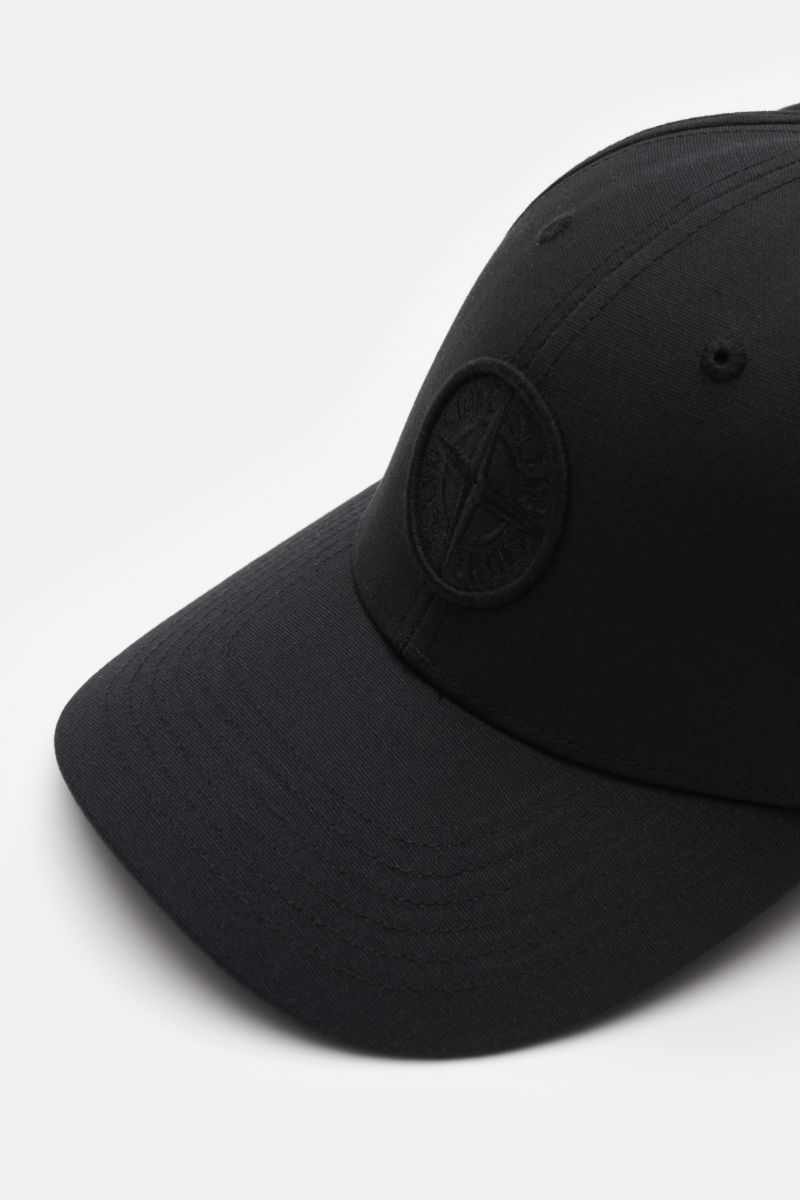Stone Island Baseball-Cap schwarz shown from a front-left angle, made of pure cotton with tonal compass stitching and curved brim.