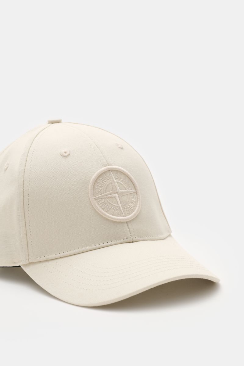 Stone Island Baseball-Cap creme shown from a front-left angle, made of pure cotton with tonal compass stitching, curved brim, and adjustable closure. Lässig mit Stil: Diese Baseball-Cap aus reiner Baumwolle von STONE ISLAND ergänzt Ihren Look mit tonal ge
