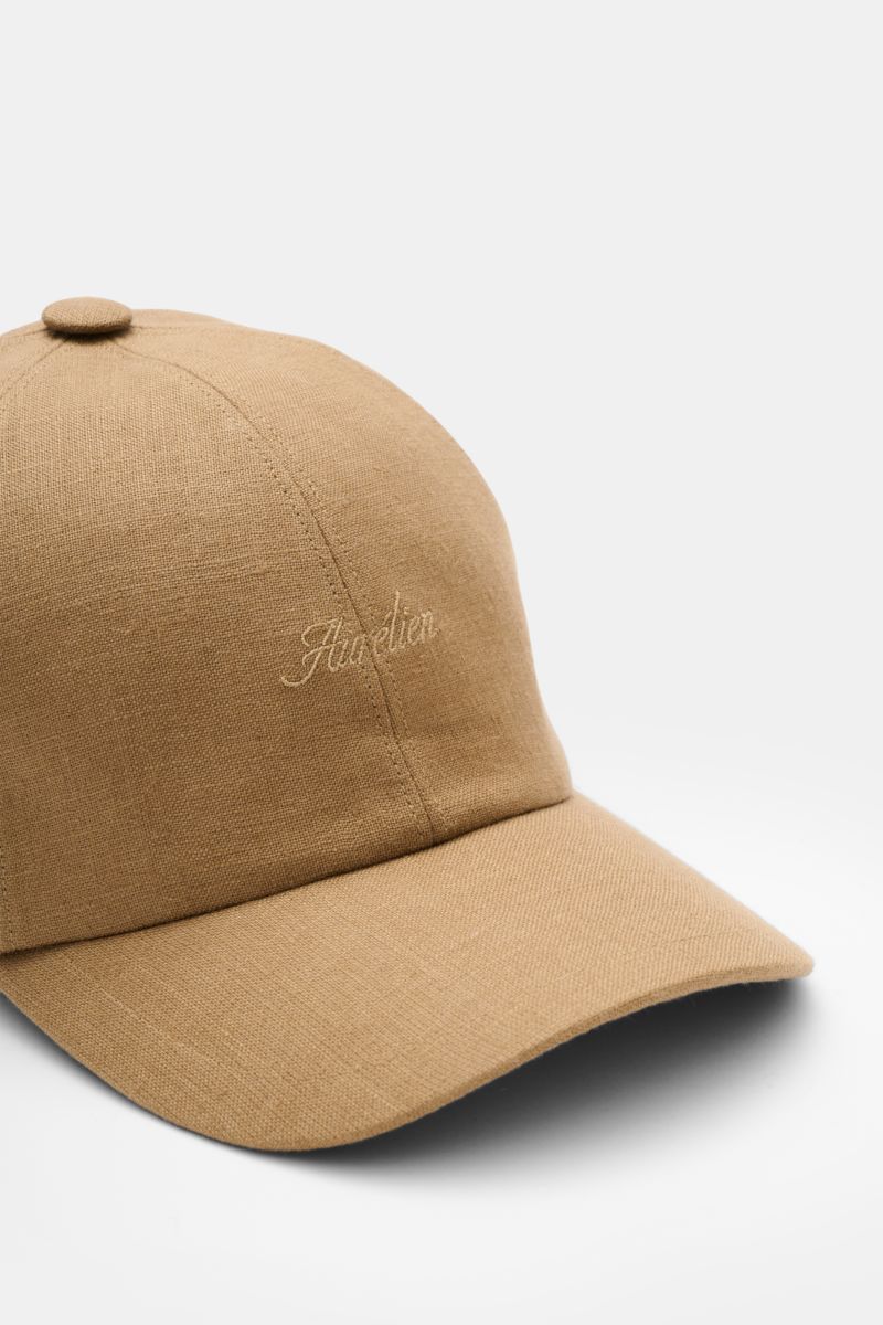 Aurélien Baseball-Cap camel aus reinem Leinen, Six-Panel-Stil mit gebogenem Schirm und tonalem Logo-Stitching, seitliche Nahaufnahme.