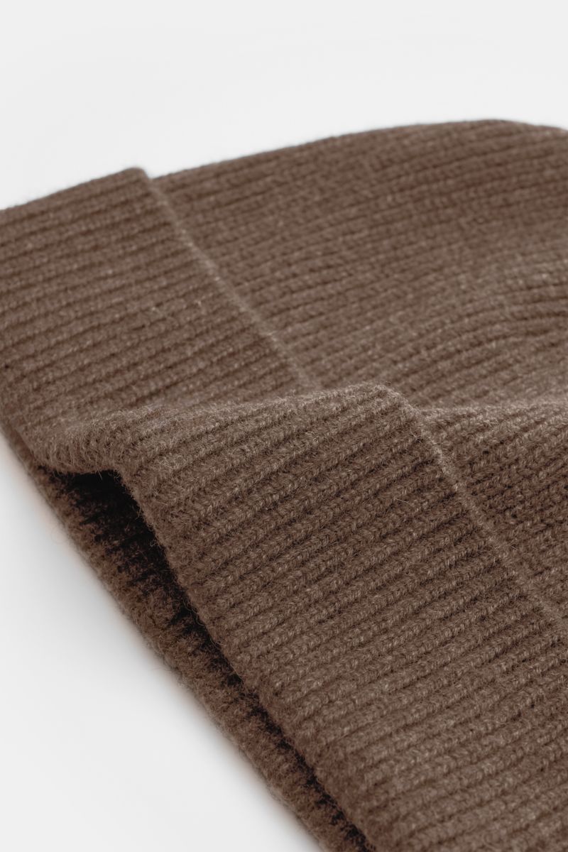 Close-up side view of the von Braun Cashmere beanie brown mottled showing its classic rib knit pattern and small turn-up edge. Whether worn with a classic winter coat or a highly functional down jacket, this soft VON BRAUN knitted beanie made of pure Mong