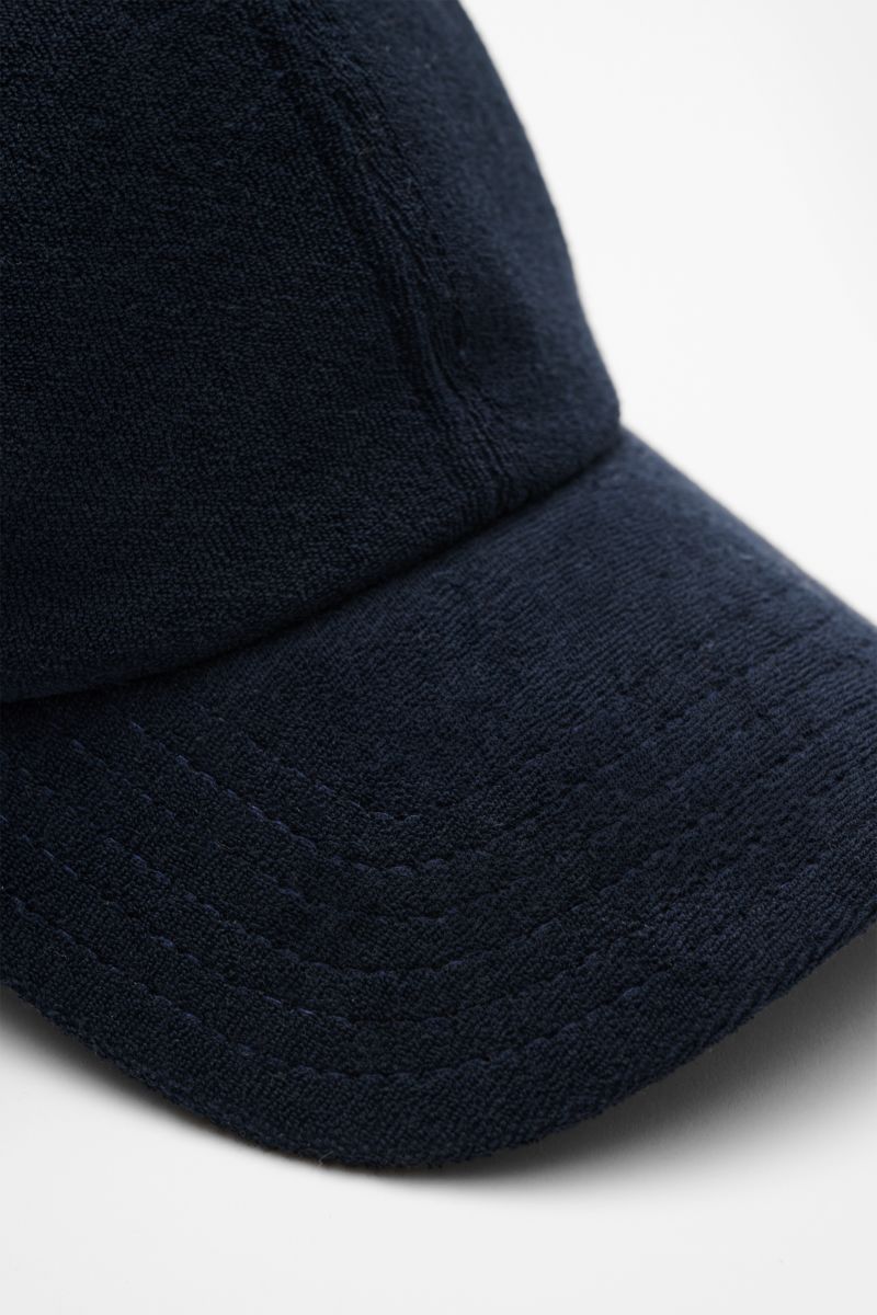 Close-up front side view of the 04651/ A trip in a bag Terry baseball cap 'Terry' navy in soft cotton terry with six panel style and adjustable closure. Spring awakening: This stylish baseball cap in soft terry by label 04651/ A TRIP IN A BAG offers good 