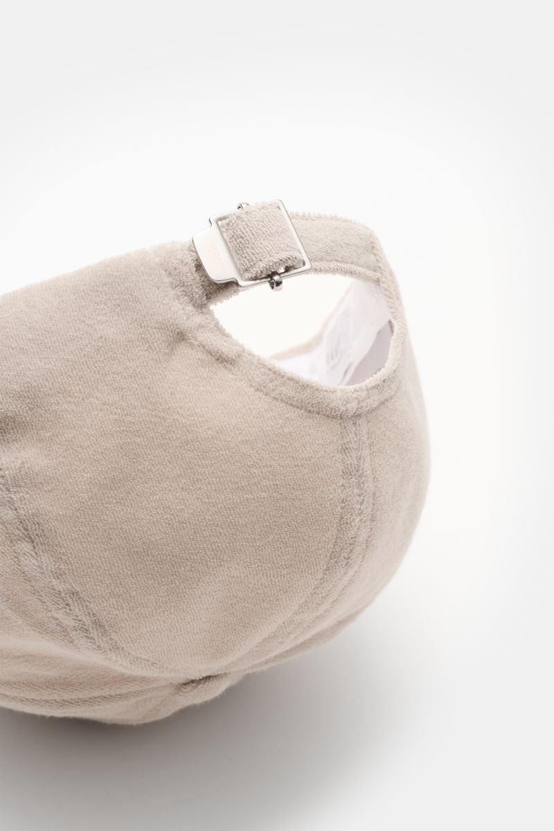 Close-up rear view of 04651/ A trip in a bag Terry baseball cap 'Terry' beige in soft cotton terry, six-panel style with adjustable metal closure.

Spring awakening: This stylish baseball cap in soft terry by label 04651/ A TRIP IN A BAG offers good pr