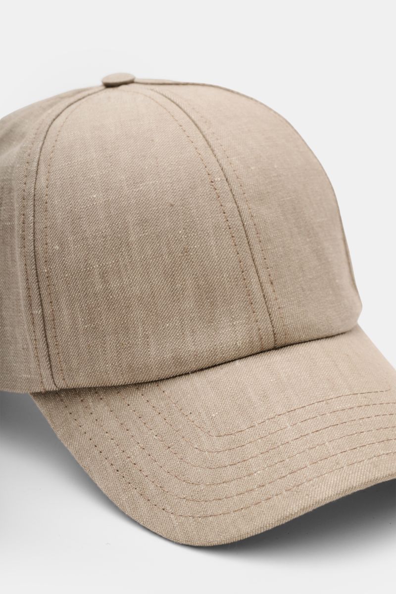 Front close-up view of the 04651/ A trip in a bag Baseball cap 'Linen' taupe mottled, made of pure linen with a slightly robust texture, six-panel style, and adjustable closure. Relaxed summer aesthetic combining lightweight natural fibres with sporty des