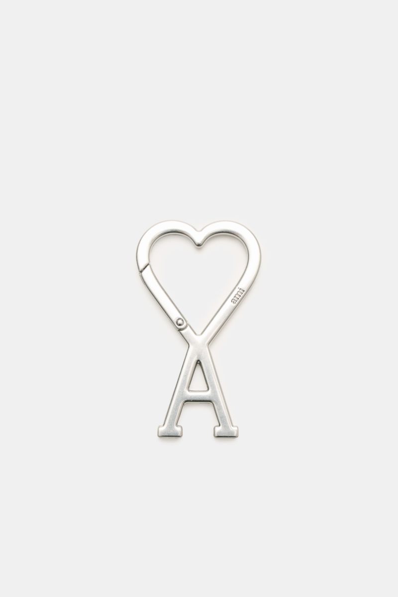 Ami Paris Schlüsselanhänger silber, unisex accessory photographed from above, shows a silver carabiner shaped as a heart with an 'A' below. Unisex Accessoire von AMI PARIS: Dieser praktische Begleiter mit dem markentypischen 'A' mit Herz hält Ihre Schl