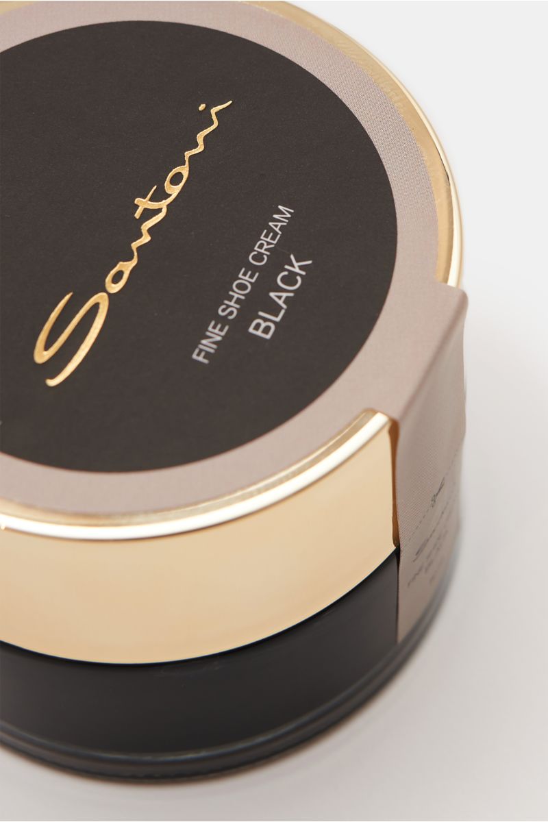 Close-up angled view of Santoni Schuhcreme schwarz 50 ml tin with black and gold lid, fine shoe cream for smooth leather.

Description:  
Unverzichtbares Utensil für die handgearbeiteten Meisterwerke von SANTONI: Perfekt auf den Schuh abgestimmt, bewir