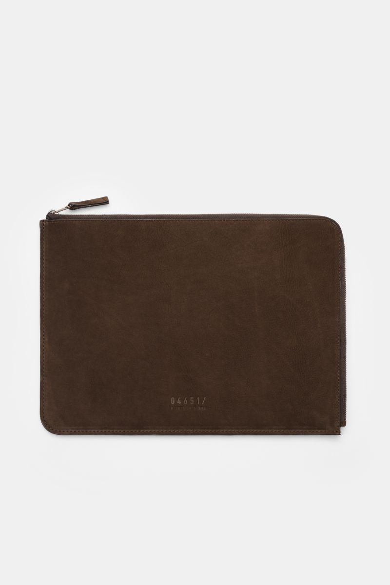 Top-down view of the 04651/ A trip in a bag Laptop Sleeve dunkelbraun, a padded, soft-lined dark brown leather case with zipper and embossed logo, designed for 14' laptops, featuring smooth velour leather, textile lining, inner slip pocket, and dimensions