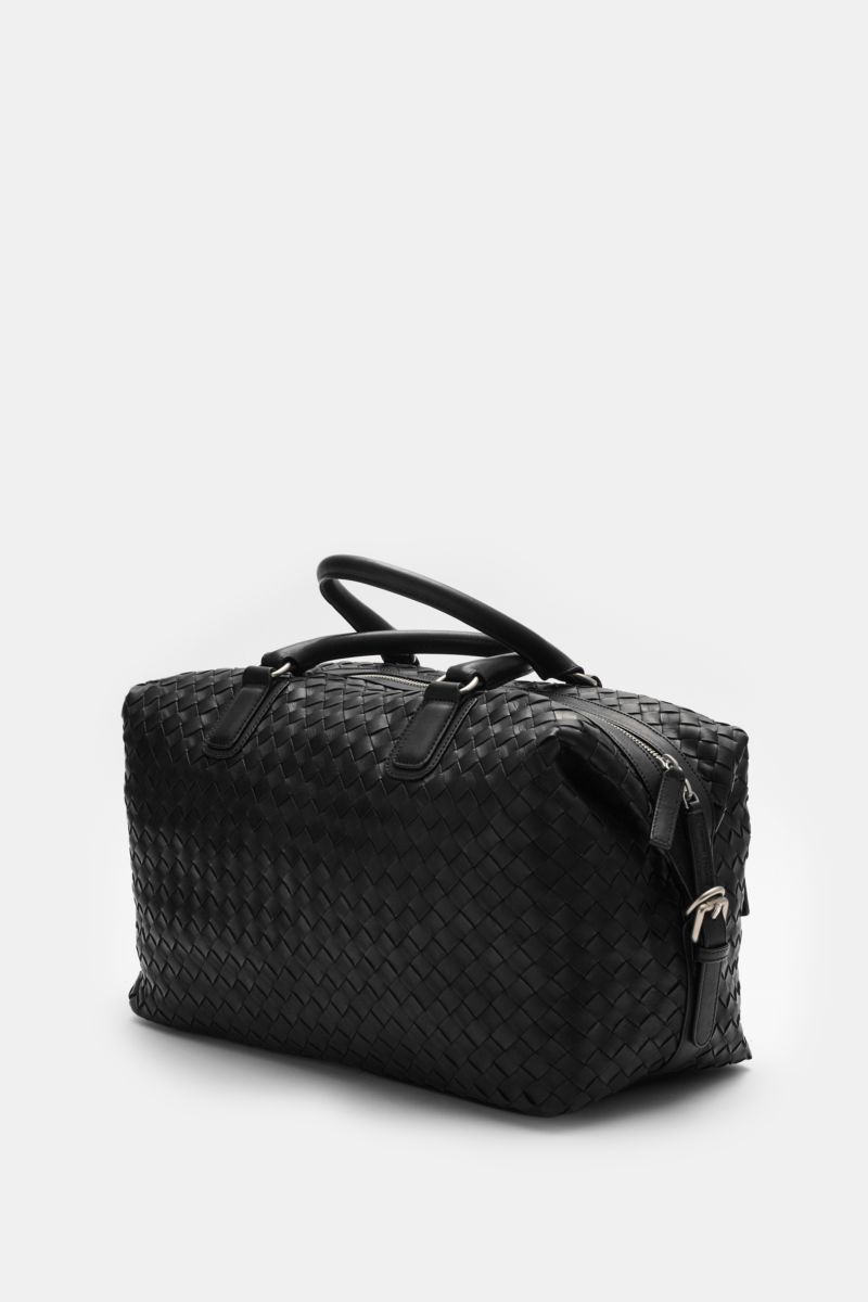 Officine Creative Weekender schwarz shown from a side angle, made of finely grained woven black leather with matte silver hardware.

Description: Mit diesem geräumigen, variabel tragbaren Weekender aus handgewebtem Leder mit matter Hardware präsentiert