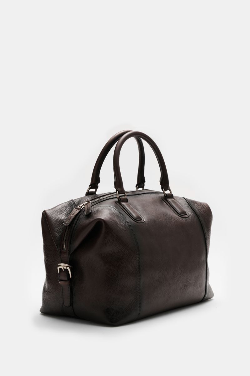 Officine Creative Weekender dunkelbraun shown from a low front-side angle, made of finely grained leather with matte silver hardware and robust handles, ideal for short trips.