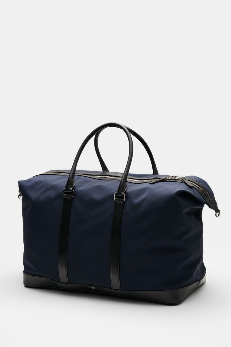 Tom Ford Weekender navy/schwarz bag photographed from a front-side angle, made of navy microfiber and black calf leather with silver hardware.

Description: Mit diesem Weekender aus robuster Microfaser und edlem Kalbleder von TOM FORD sind Sie perfekt 