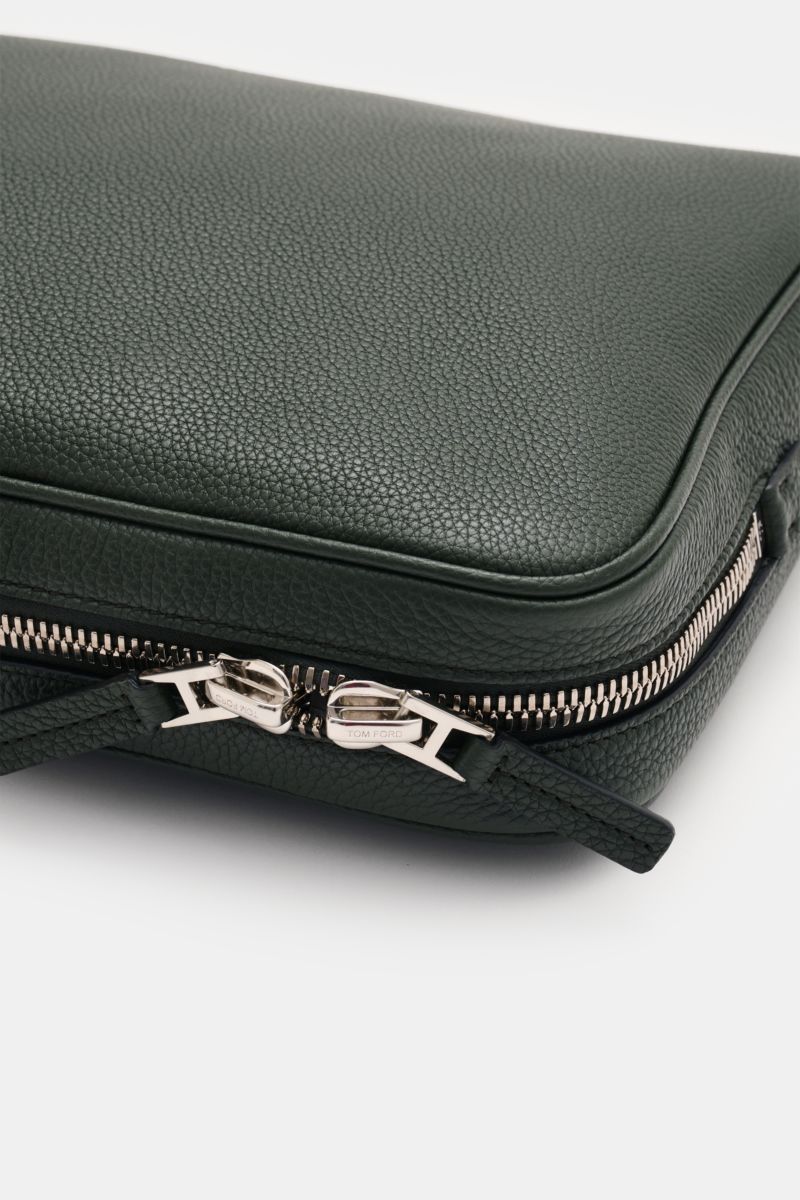 Tom Ford Laptop Sleeve dunkelgrün aus genarbtem Kalbleder mit silberfarbener Hardware, Logo-Prägung, Nahaufnahme der Ecke mit Reißverschluss.