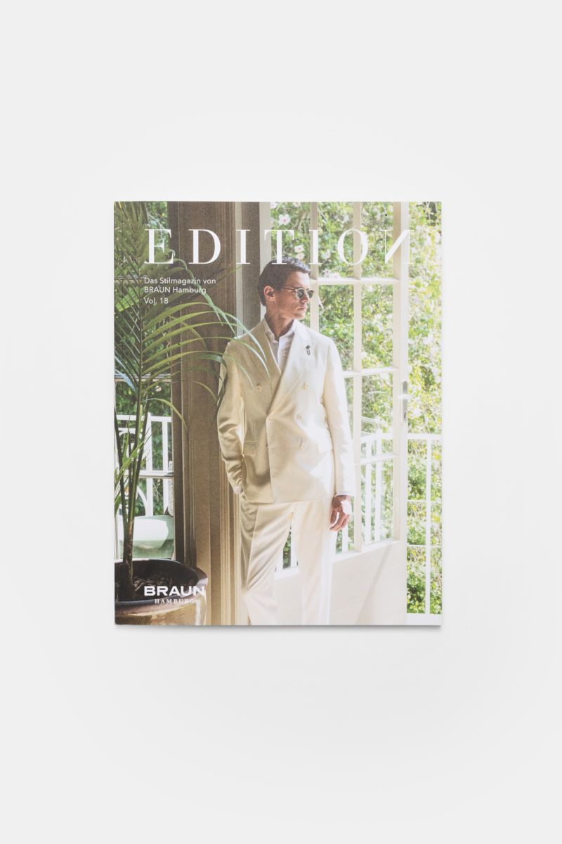 Front view of Edition EDITION Magazin Frühling 2026 showing a man in a white suit by a sunlit window with greenery and indoor plant.