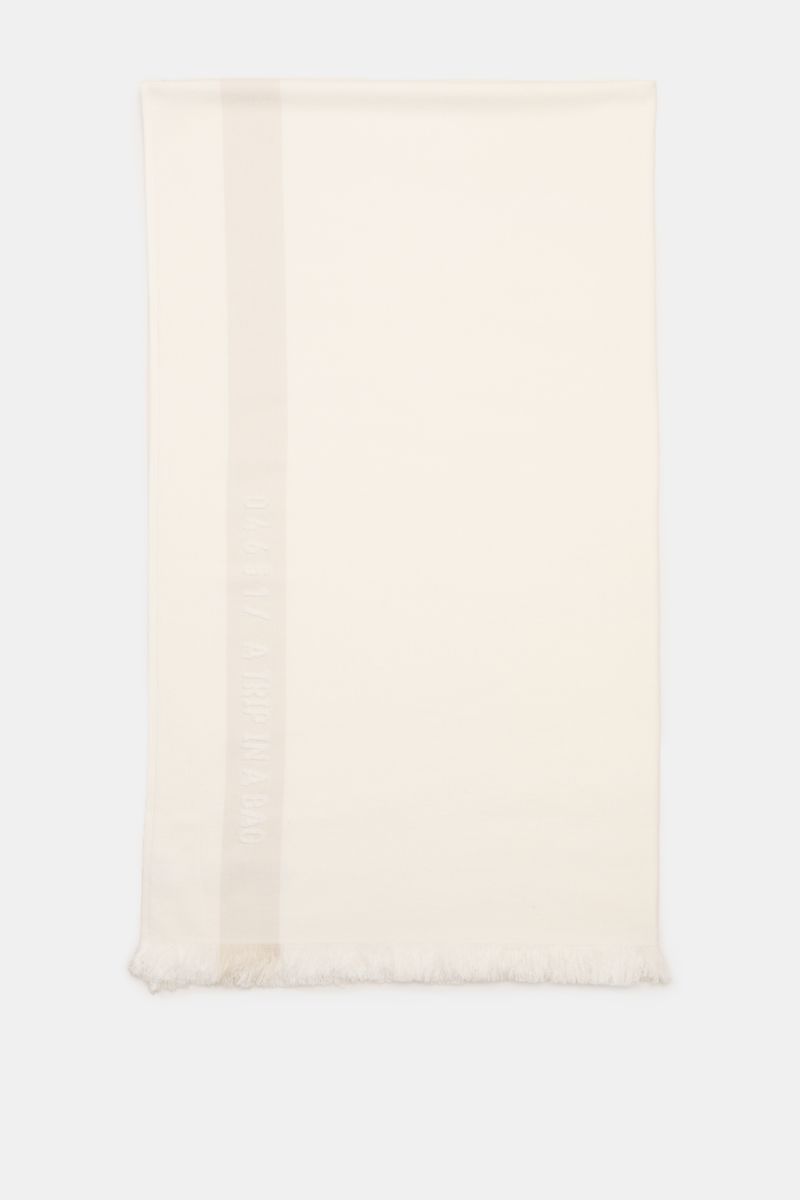 Top-down view of the 04651/ A trip in a bag Strandtuch offwhite beach towel made of pure cotton terry with a narrow fringed edge, measuring approx. 95 x 175 cm. 

Elegantes Strand-Accessoire: Das Strandtuch aus reinem Baumwoll-Frottée von 04651/ A TRIP