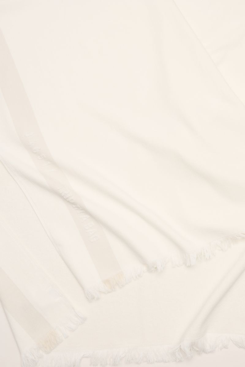 Close-up top view of 04651/ A trip in a bag Strandtuch offwhite beach towel in soft pure cotton terry with narrow fringed edges, size approx. 95x175 cm.

Elegantes Strand-Accessoire: Das Strandtuch aus reinem Baumwoll-Frottée von 04651/ A TRIP IN A BAG