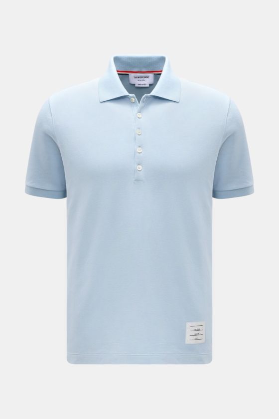 Vorderansicht des Thom Browne Poloshirts hellblau aus reiner Baumwolle, Slim Fit mit klassischem Polokragen, Fünf-Knopf-Leiste, Rippbündchen an Ärmeln und elastischen Seiteneinsätzen, markentypisches Streifen-Logo. Vorderansicht des Thom Browne Poloshirts hellblau aus reiner Baumwolle, Slim Fit mit klassischem Polokragen, Fünf-Knopf-Leiste, Rippbündchen an Ärmeln und elastischen Seiteneinsätzen, markentypisches Streifen-Logo.